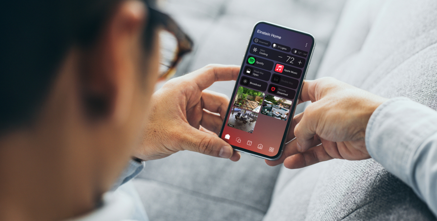 A person holding a smartphone displaying the Control4 platform and security camera feed.