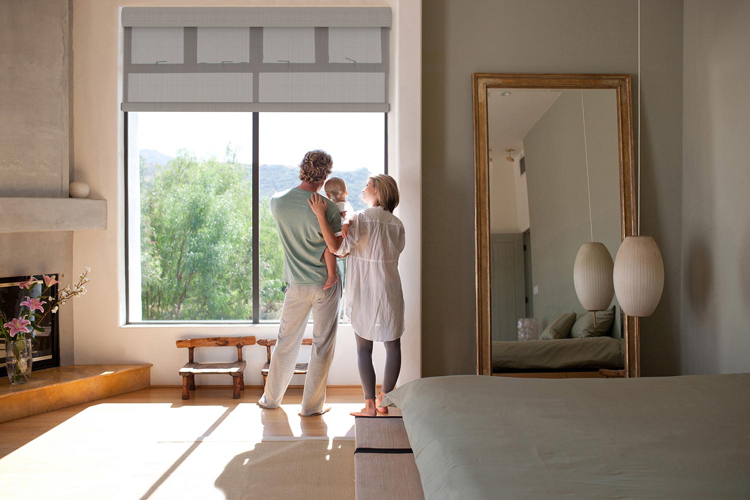 Family looking out a large bedroom window at nature
