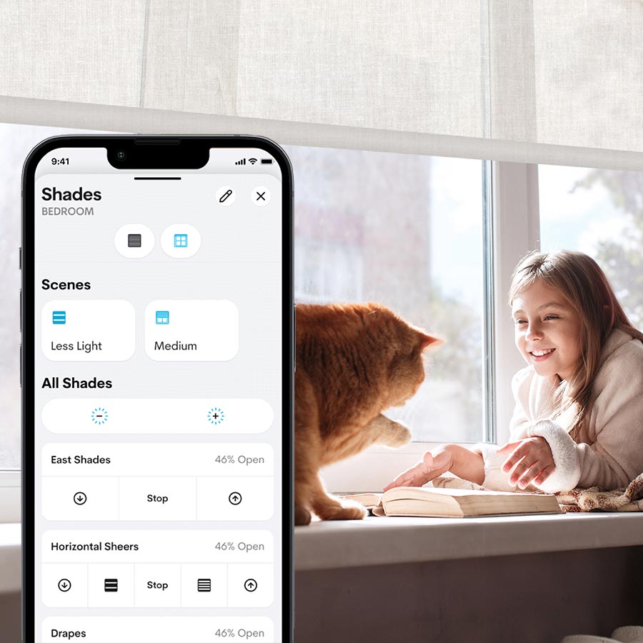 Smartphone displaying a smart shade control app in front of a girl and cat by a window