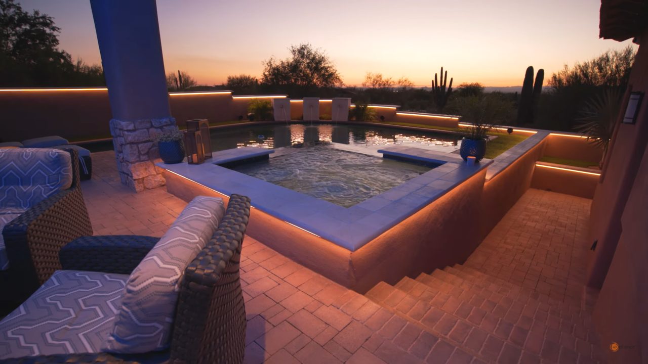 A luxurious outdoor space with elegant lighting design around the pool and outdoor living areas.