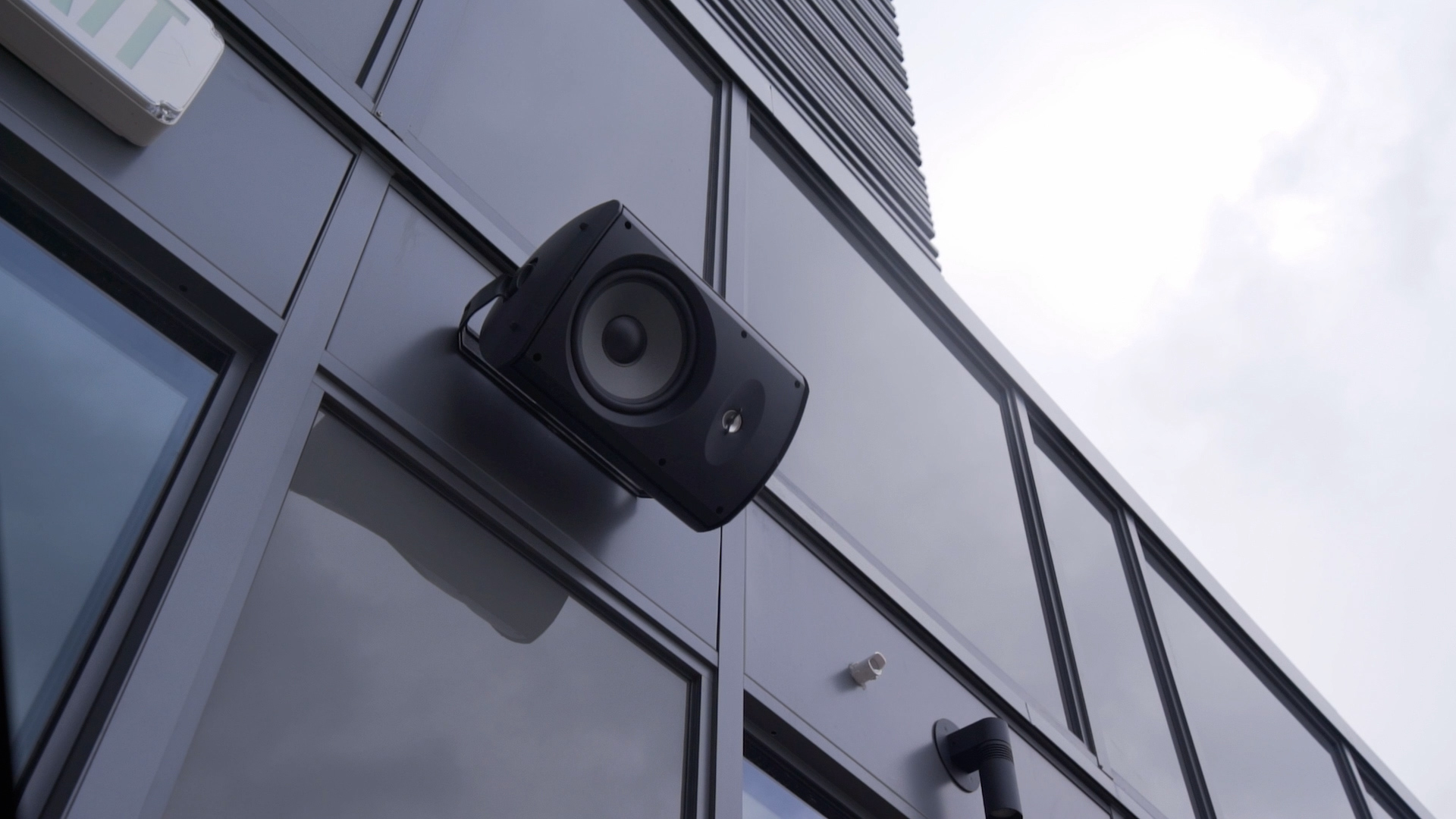 Exterior view of a speaker mounted on the side of a building, overlooking the cityscape.
