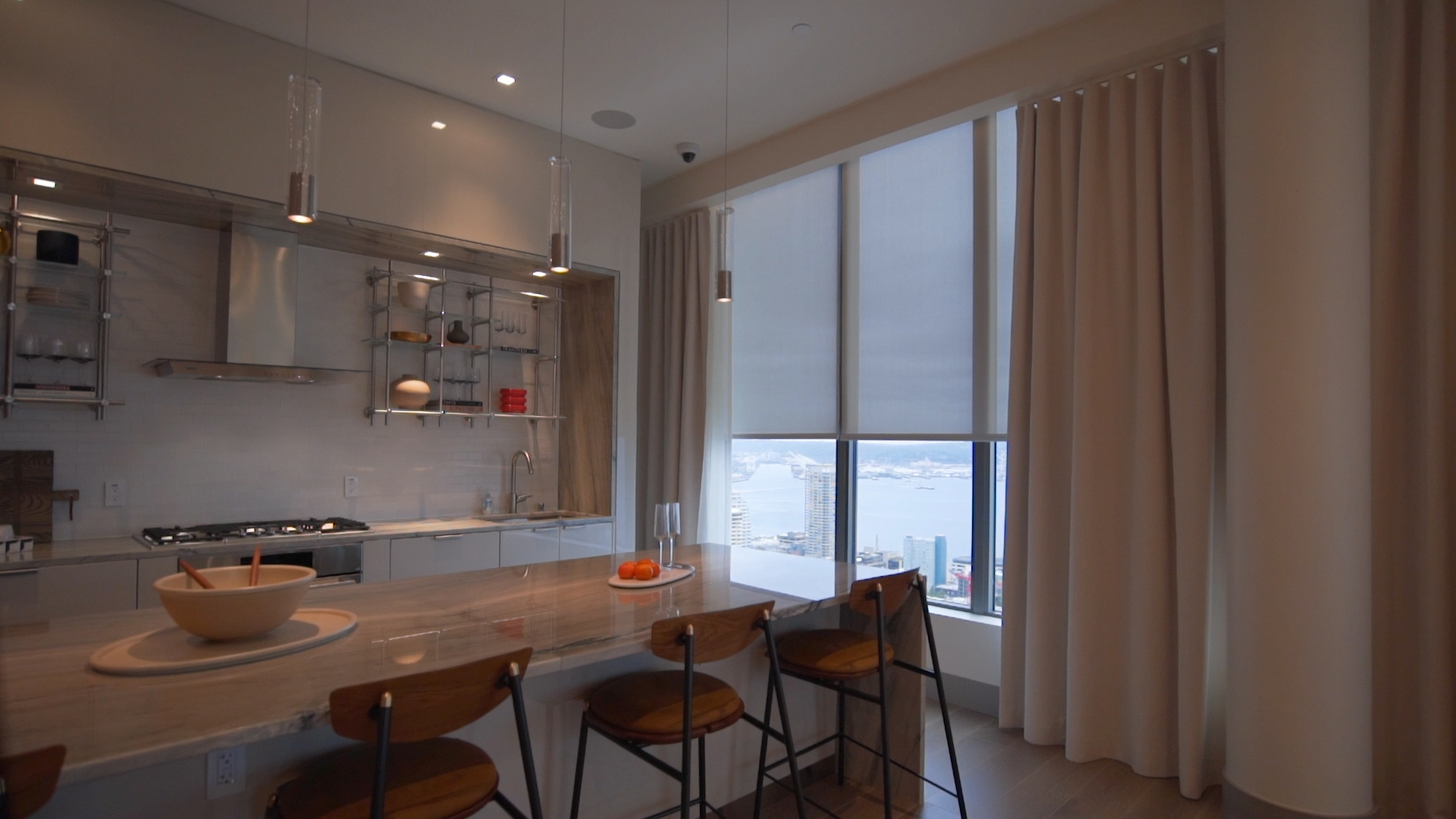 Bright kitchen with countertops and modern fixtures, featuring automated shades and Seattle views.