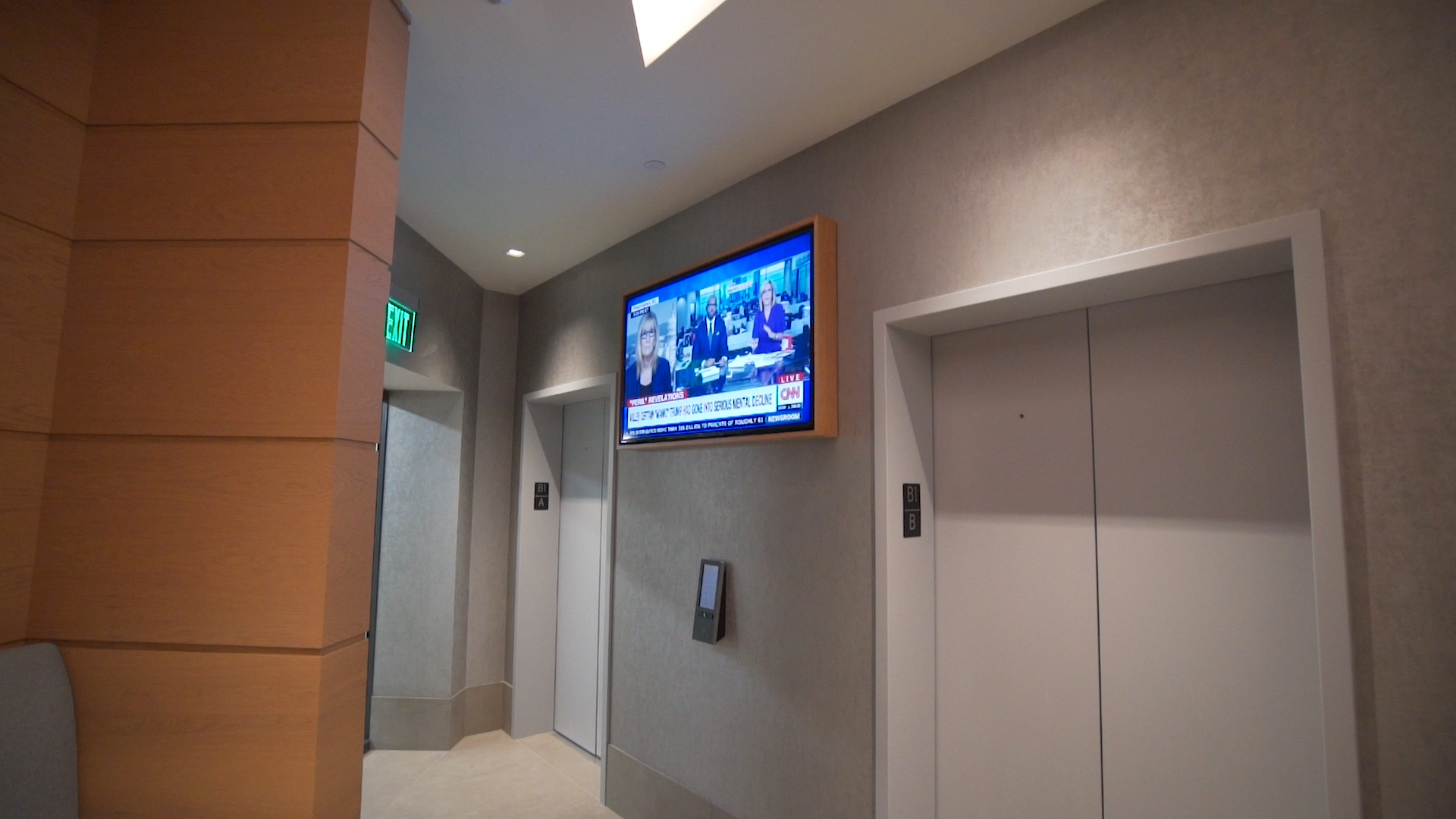 Hallway with elevator and TV mounted on the wall, providing a clean and modern design for common areas.