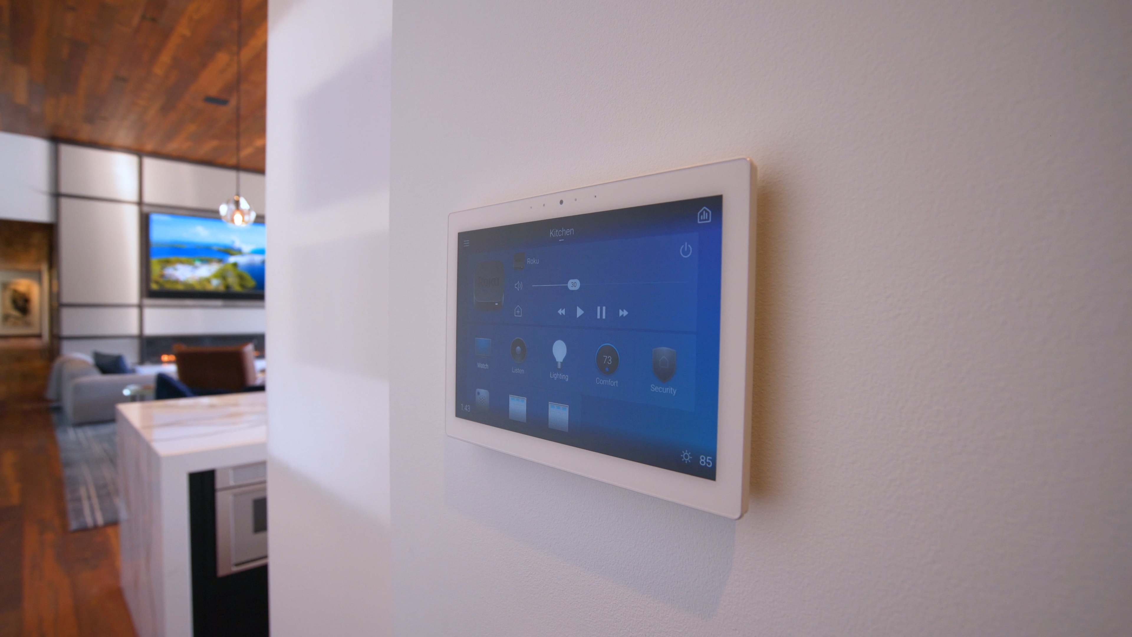 A wall-mounted smart home control tablet in the kitchen, managing lighting, temperature, and security.