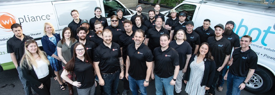 Wipliance and Obot Electric team members posing together in front of branded company vans