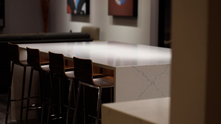 A sleek modern kitchen with a white marble countertop illuminated with expert lighting design by Wipliance.