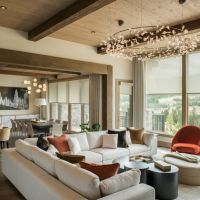 Modern living room with Lutron light-filtering motorized shades lowered over windows with a mountain view.