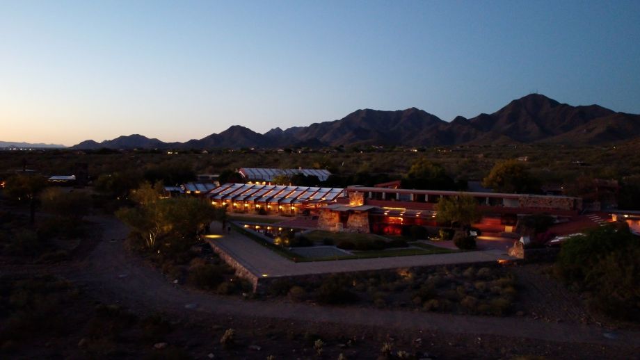 Aerial dusk view of Taliesin West showing warm LED lighting highlighting Frank Lloyd Wright&rsquo;s desert‑inspired architecture.