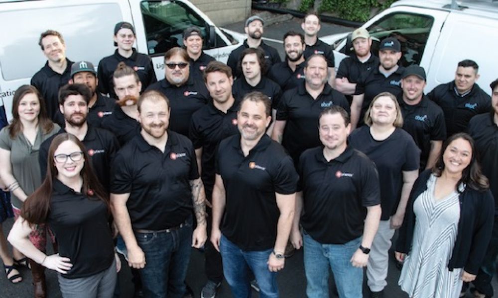 Wipliance and Obot Electric team members posing together in front of branded company vans