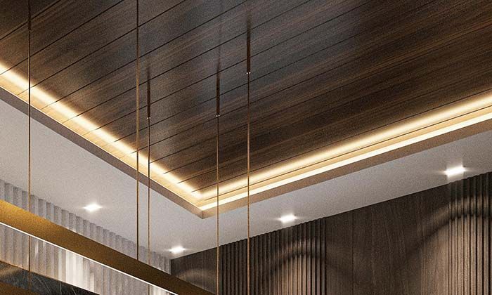 a corner of a ceiling with wooden paneling featuring cove lighting